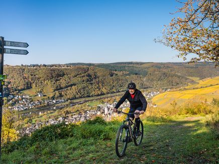 mountainbiker-in-actie-uitzicht-op-enkirch Mountainbiker met uitzicht op Enkirch in herfst